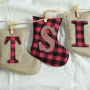 Rustic Christmas burlap stockings with red plaid letters T S I and wooden clips for decor