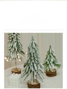 Detail of mini flocked Christmas trees with LED lights and natural wooden bases