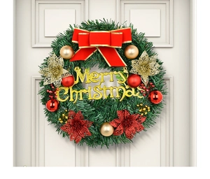 Detail of Christmas wreath with red bow, ornaments, and Merry Christmas sign on white door