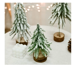 Miniature pine needle Christmas trees with white snow powder and natural wood bases