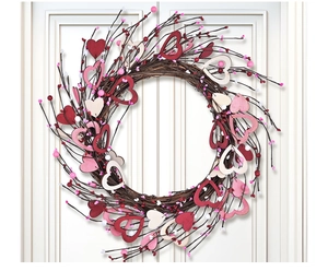 Close-up of Valentine heart wreath with wooden hearts and pink berries on white door