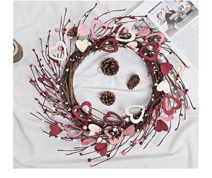 Detail of a handmade heart wreath with natural twigs, multi-color wooden hearts and berries