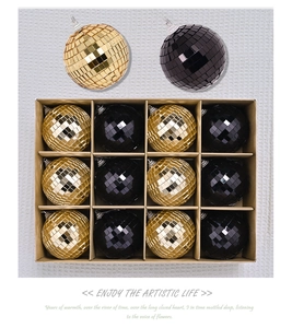 Macro view of gold and black mirrored disco ball ornaments in a kraft paper gift box
