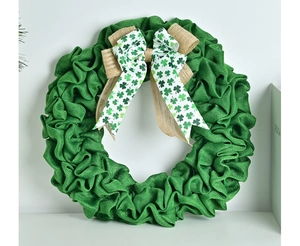 Detail of green burlap St. Patrick's Day wreath with clover pattern ribbon bow