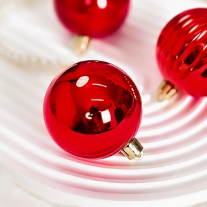 Glossy red Christmas baubles with gold caps on a spiral display stand for tree decor