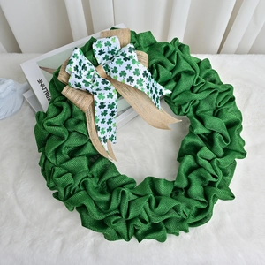 St. Patrick's Day green burlap wreath with shamrock ribbon bow on white plush rug decor