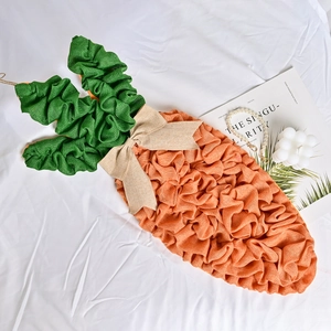 Handmade burlap Easter carrot wreath decoration with a bow on white textured fabric