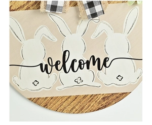 Close-up of wooden Easter welcome sign with white bunnies and a rustic burlap bow
