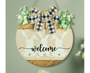 Close-up of wooden Easter welcome sign with white rabbit silhouettes and eucalyptus decor