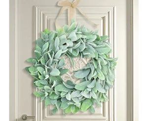 Detail of flocked lamb's ear wreath with burlap bow hanging on a white wooden door