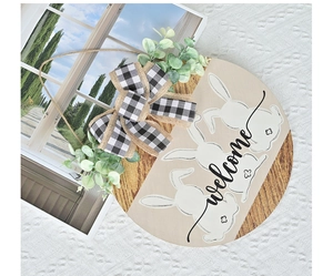 Close-up of Easter wooden welcome sign with rabbit silhouettes and buffalo plaid bow