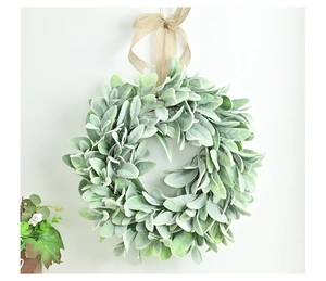 Detail of lamb's ear wreath with flocked green leaves and a beige burlap bow decoration