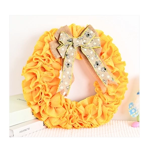 Détail d'une couronne de fête des abeilles en jute jaune avec nœud et motifs marguerites