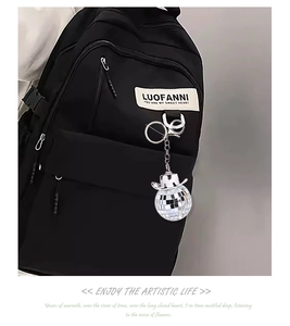Close-up of disco ball keychain with white cowboy hat on a black backpack strap
