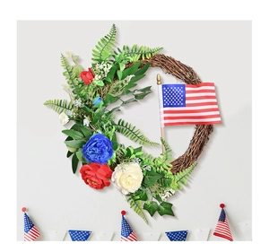 Detail of patriotic grapevine wreath with red white blue flowers and US flag for door decor
