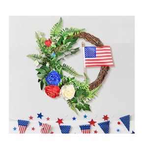 Close-up of patriotic rattan wreath with red white blue flowers and small US flag