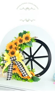 Detailed view of sunflower wreath with vintage wooden wheel and yellow plaid bow
