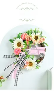 Détail de la couronne fleurie avec camion rose en bois et nœud vichy noir et blanc
