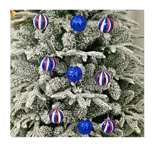 Detail of glittery blue and American flag striped Christmas ornaments hanging on snowy pine