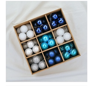 Overhead shot of assorted Christmas ball ornaments in a nine-grid kraft paper box