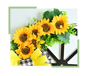 Detailed view of yellow sunflowers and checkered bow on rustic black wheel frame