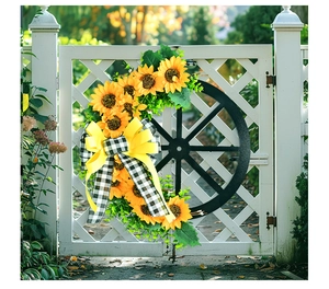 Detail of sunflower wreath with a black wagon wheel frame and checkered bow on a white door