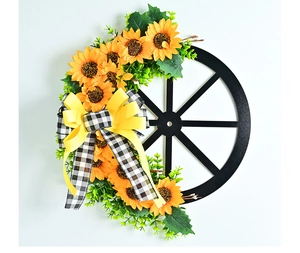 Rustic wall wreath featuring sunflowers, a black wagon wheel, and a yellow checkered bow