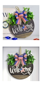 Detail of wooden Welcome sign with American flag bow and artificial greenery on a white door