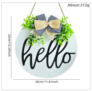 Dettaglio di una targa per porta hello bianca con fiocco blu e dimensioni di 30 cm incluse