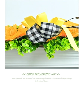 Macro detail of artificial sunflowers with yellow and checkered bows on a floral wreath