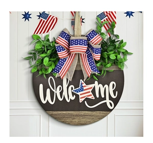 Detail of wooden American Independence Day welcome sign with star bow and lush greenery