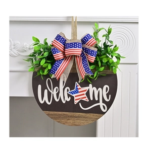 Detail showing the American flag bow and realistic greenery on the wood welcome sign