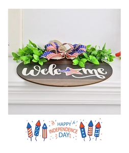 Detailed close-up of Independence Day wooden welcome sign with burlap bow and greenery