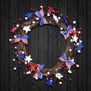 Patriotic July 4th door wreath with red, white and blue berries on dark wood background