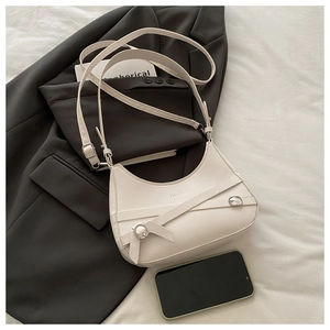 Detail of cream crescent hobo bag with adjustable strap and silver metal buckle decoration