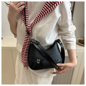 Detail of a black crescent PU leather bag featuring a silver buckle and bow decoration