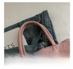 Detail of pink hobo bag featuring soft padded handles and wrinkled nylon fabric texture