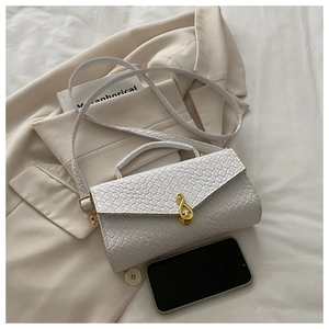 Detail of white woven texture bag featuring a golden treble clef music note metal buckle