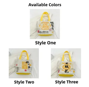 Detailed view of canvas tote bags with cultural prints and yellow ribbon handles