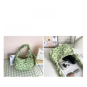 Detail of the green floral handbag with pleated handle and spacious interior storage
