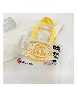 Detailed macro view of canvas tote bag with traditional Chinese calligraphy and yellow handles