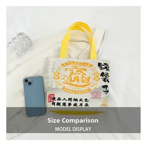 Canvas bag detail showing the size comparison with a smartphone on white fabric