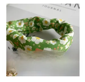 Close-up of green fabric with daisy print showing detailed woven texture and patterns