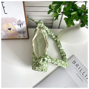 Top view of green floral ruched armpit bag with white daisy print and silver zipper