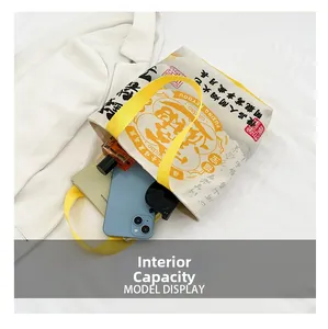 Internal capacity view of a canvas tote bag showing phone, sunglasses and a notebook