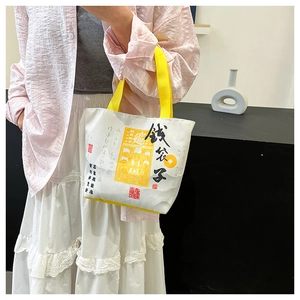 Detail of creative canvas tote bag with Chinese calligraphy and yellow top handles