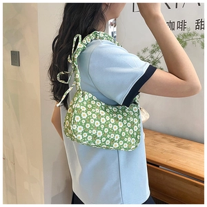 Detail of floral shoulder bag with white daisies and an elegant bow on the strap