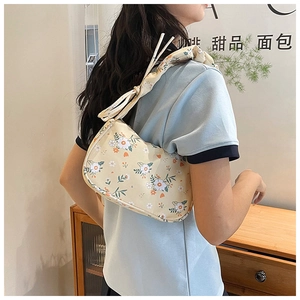 Detail of floral underarm bag with pleated drawstring shoulder strap and daisy print