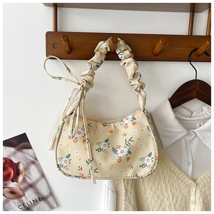 Close-up of floral print underarm bag with pleated handle and yellow floral pattern