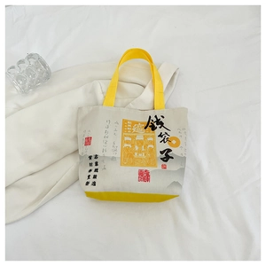 Detailed macro view of the durable canvas tote bag with yellow handles and folk art prints